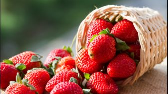 A small basket full of strawberries in natural background.jpg