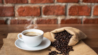 Hot coffee in white cup and roasted coffee beans