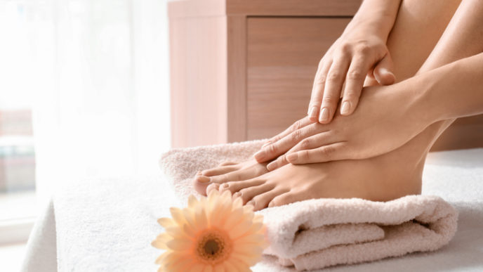 Young woman with beautiful pedicure and manicure after treatment in spa salon