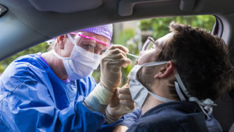 A doctor taking a nasal swab from a driver