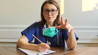 Female doctor looking at webcam, video conference