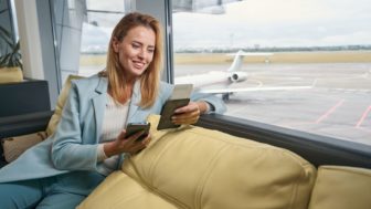 Happy tourist looking at boarding ticket in her hand