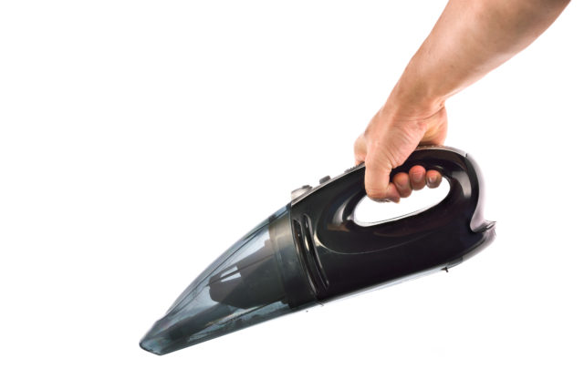 Hand hold vacuum cleaner on white background