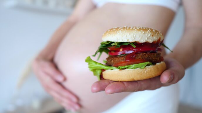tehotná žena s hamburgerom