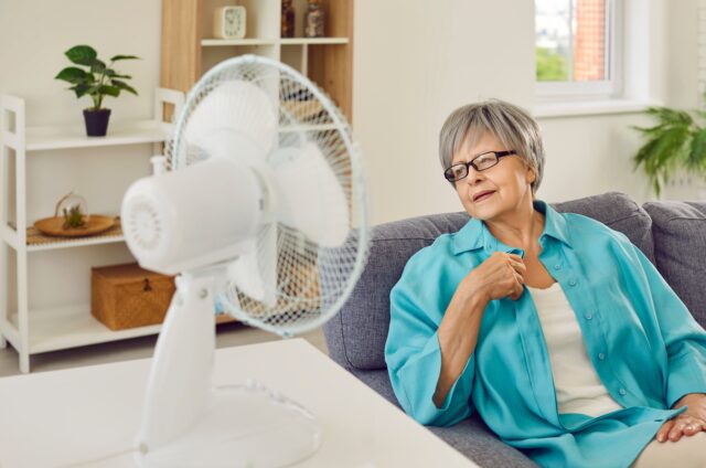 seniorka sedí pri zapnutom ventilátore