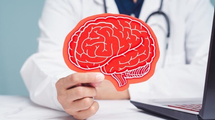 doktor držiaci maketu mozgu