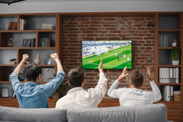 muži sledujúci futbal