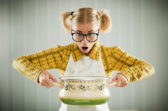 Blonde geek holding cooking pot.