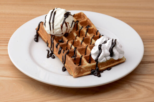 Hotové wafle servírujte s čokoládovou polevou a poriadnou dávkou šľahačky.