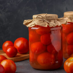 Homemade salted tomatoes in jars on a dark background, Fermented food, closeup