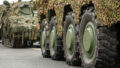 Column of various armoured tanks moving on the road