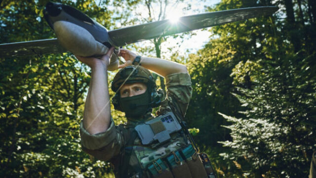 564505_drones_soldier_holding_pre launch_drone_in_forest 676x450 1.jpg