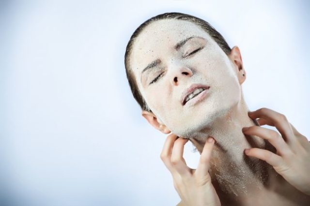Žena s vysušenou pokožkou na tvári si škriabe krk