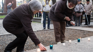 Ľudia zapaľujú sviečky počas verejného zhromaždenia pri príležitosti výročia sviečkovej manifestácie.
