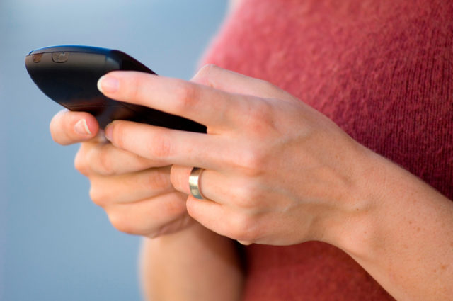 Close up of a women's hands using a cellular PDA.