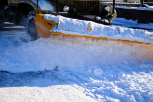 Snow plow truck workiyng in a city park. Kremenchug, Ukraine