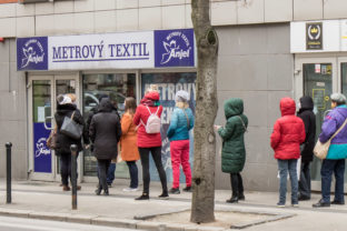 Zákazníci čakajúci v rade pred predajňou metrového textilu po zavedení nových opatrení vlády SR, ktoré umožnili otvoriť ïalšie obchody, služby a prevádzky počas mimoriadnej situácie v súvislosti s ochorením COVID-19 spôsobeným koronavírusom (2019-nCoV). Bratislava, 30. marec 2020.