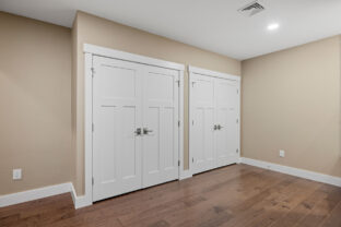 Clean empty living room with multiple white and a dark wood floor