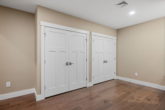 Clean empty living room with multiple white and a dark wood floor