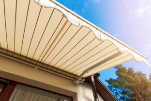 Awning over balcony window against blue sky