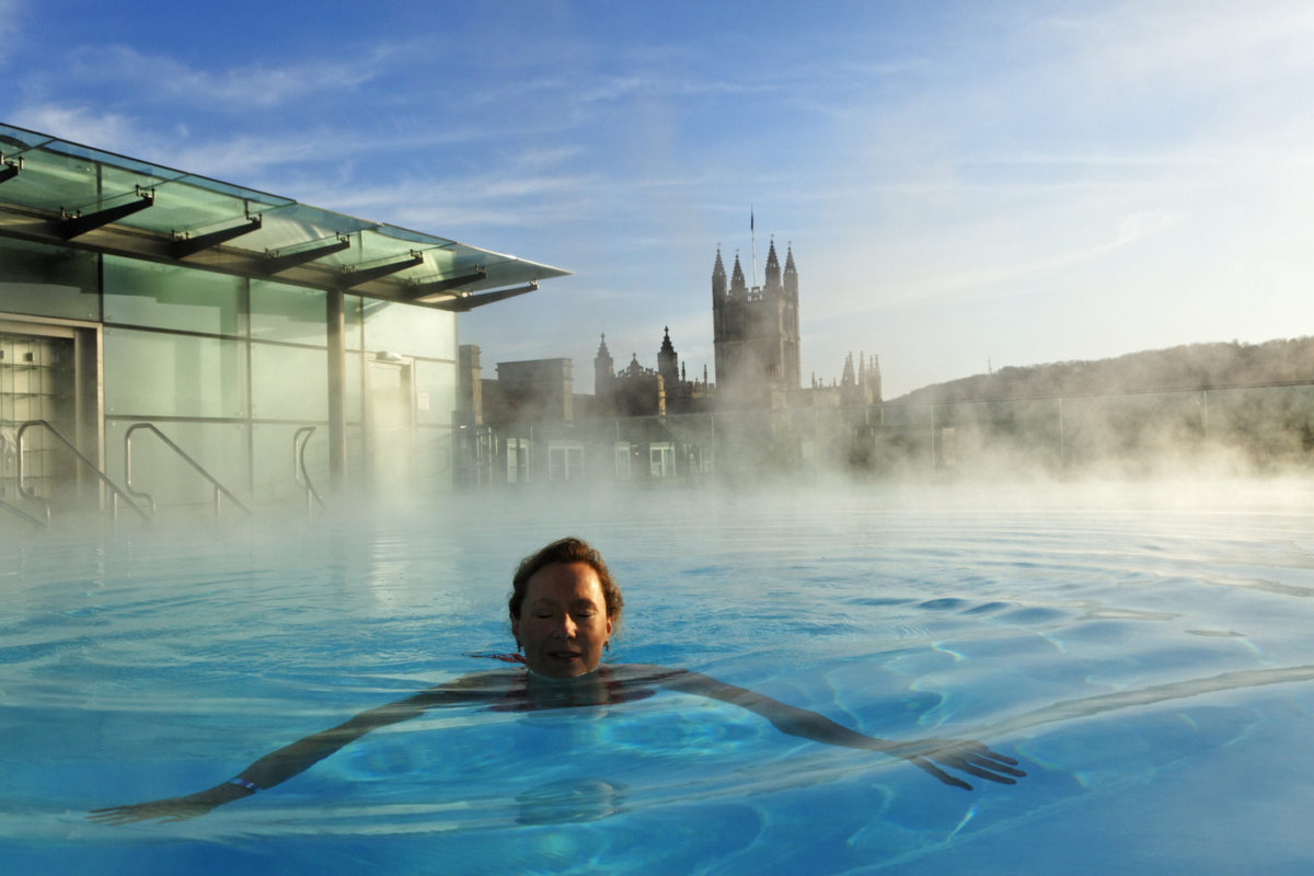 A woman swimming in the rooftop swimming pool at the roman bath, Bath