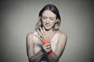 Woman holding her painful wrist