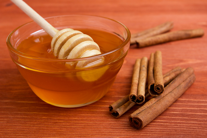 Wooden honey stick and cinnamon sticks.