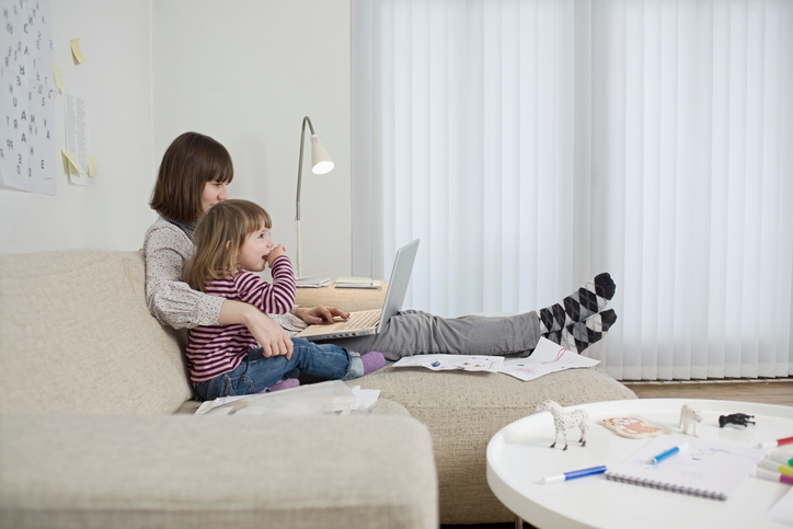 Mother and daughter with laptop in living room