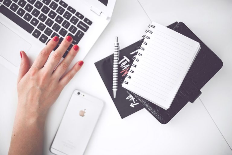 Woman hand smartphone desk.jpg