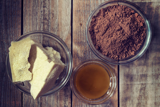 Cocoa butter, cocoa powder and honey on grunge wooden background