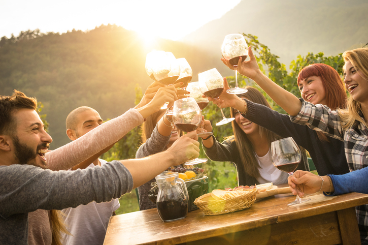 Happy friends having fun an drinking wine in autumn time