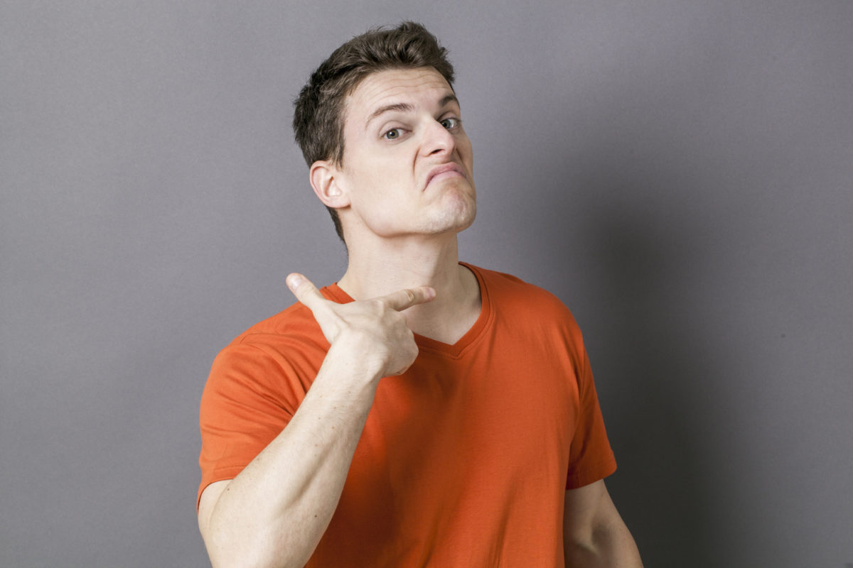 Mad young sportsman showing his throat for sign of victim
