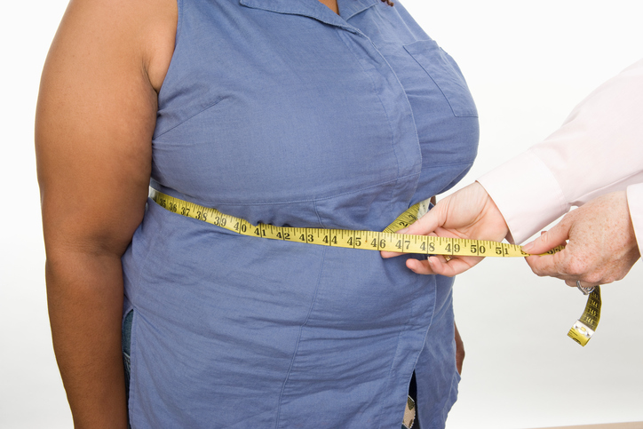 Doctor taking measures of overweight mid adult woman