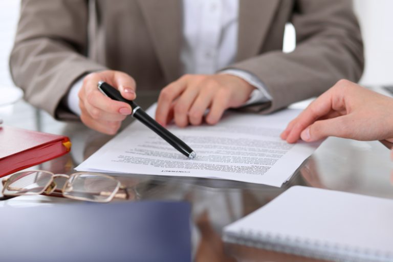 Group of business people and lawyers discussing contract papers sitting at the table, close up