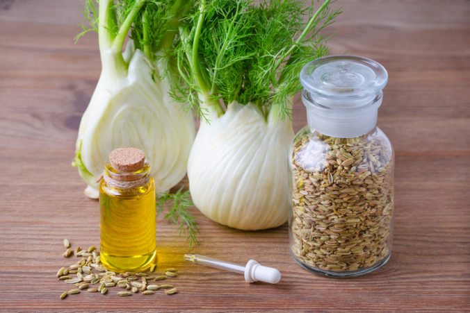 Fennel essential oil, bulb and seeds, a pipette selective focus on wooden