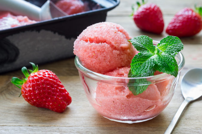 Homemade strawberry sorbet in glass on a wooden table