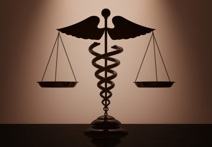 Medical Caduceus Symbol as Scales with backlight over Wall