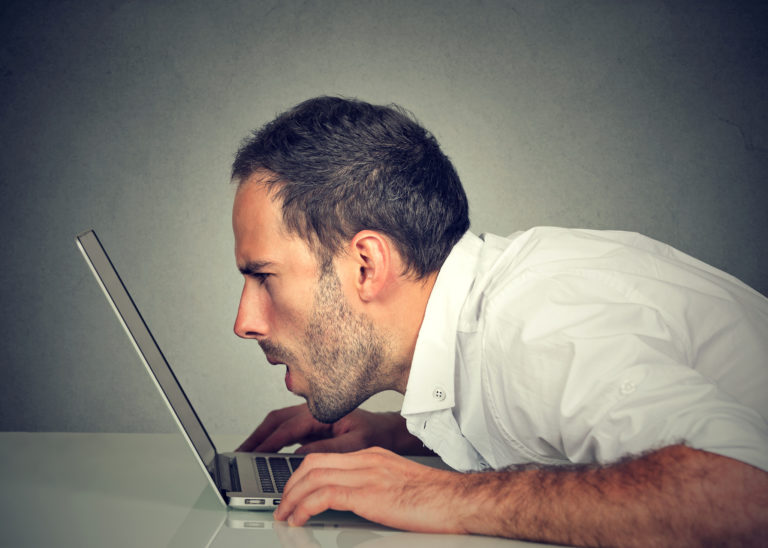 Man with vision problems using computer reading email