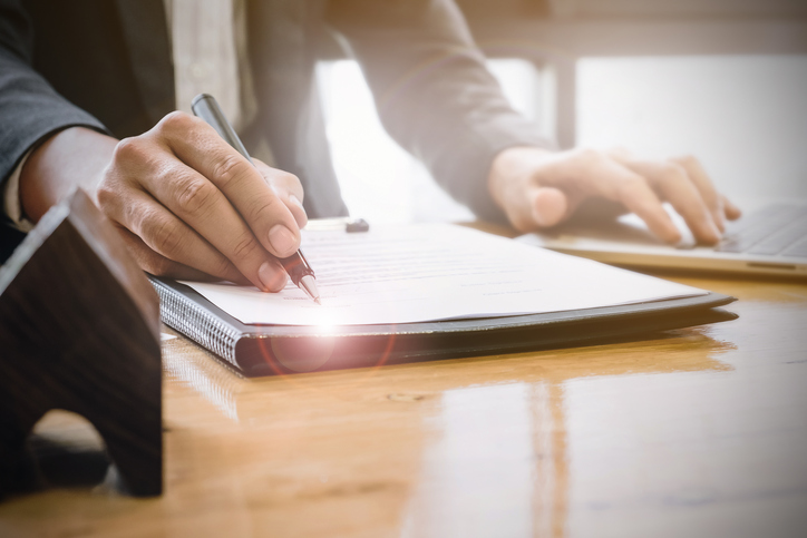 Close up of Business man pointing and signing agreement for buying house. Bank manager concept.
