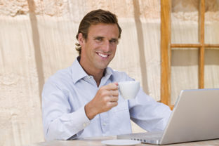 Man with teacup and laptop computer