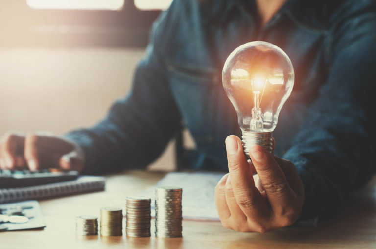 Business accountin with saving money with hand holding lightbulb concept financial background