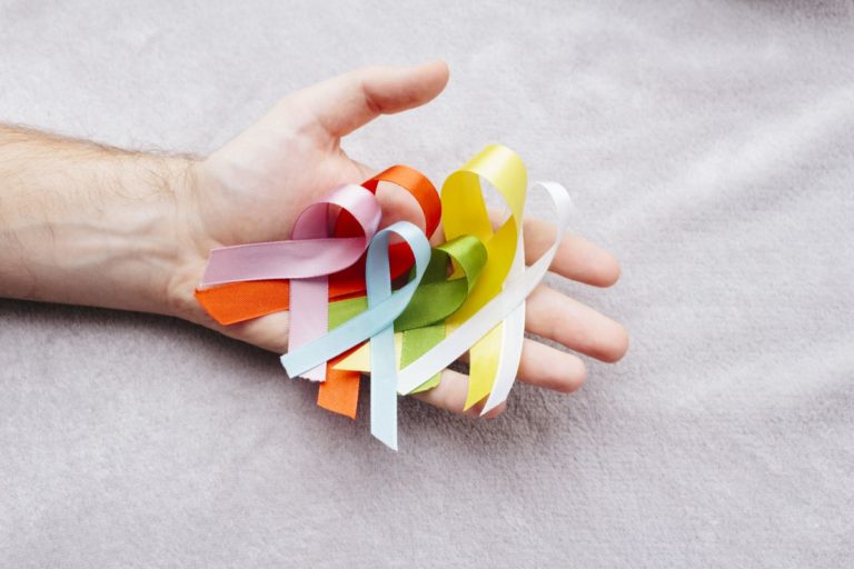 Hand holding cancer awareness ribbon