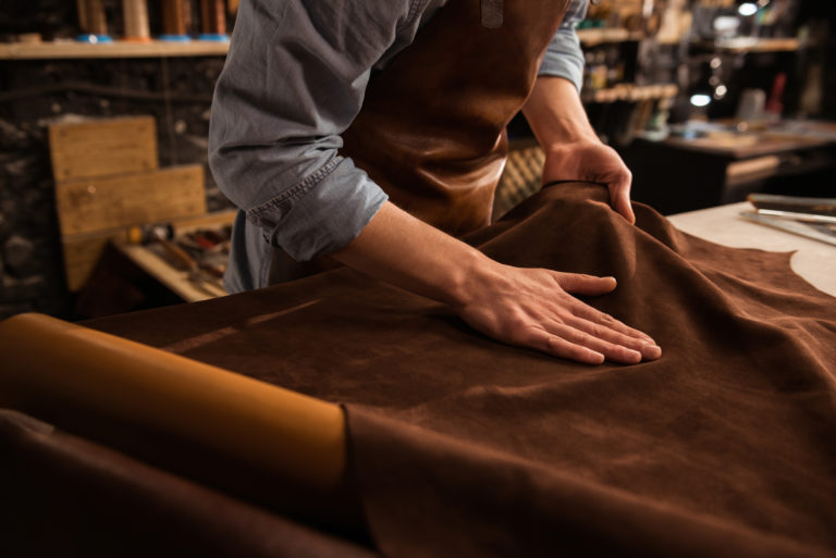 Close up of a cobbler working with leather textile