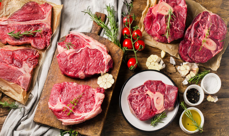 Raw beef meat on a dark wooden board.