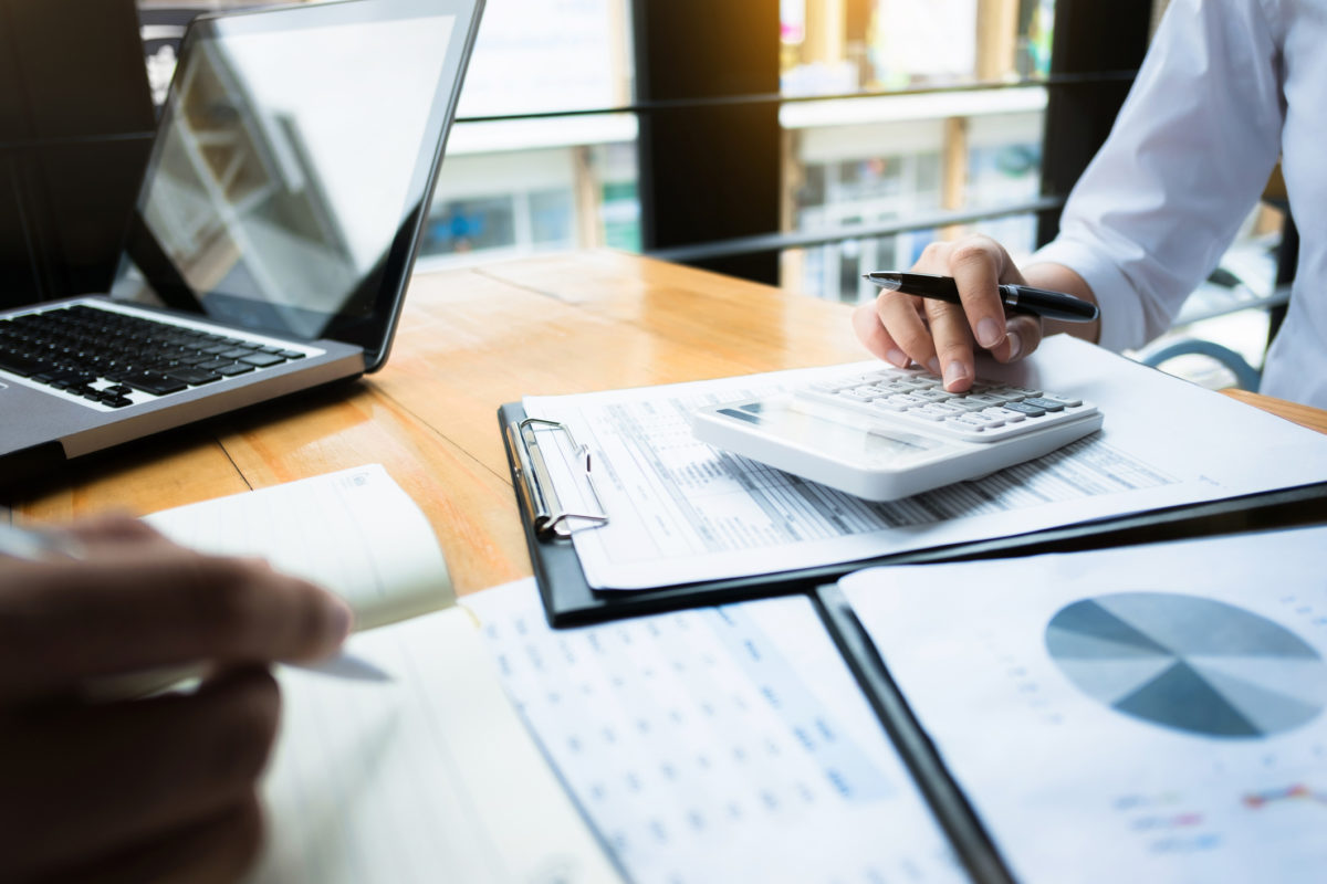 Business audits using a calculator financial data investment fund at a workplace, wealth concept