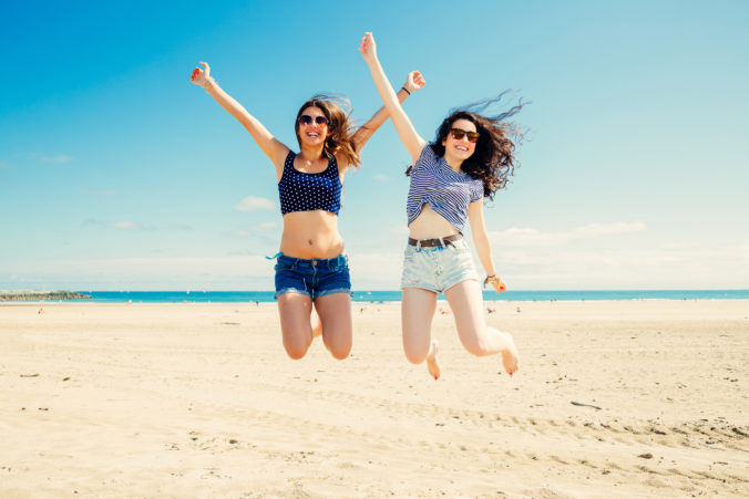Funny girl frinds jumping on the beach