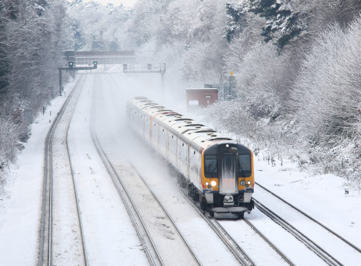 Train transporting commuters in winter snow and ice to London