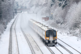 Train transporting commuters in winter snow and ice to London