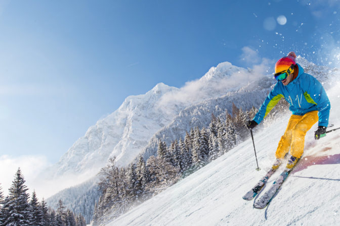 Skier skiing downhill in high mountains