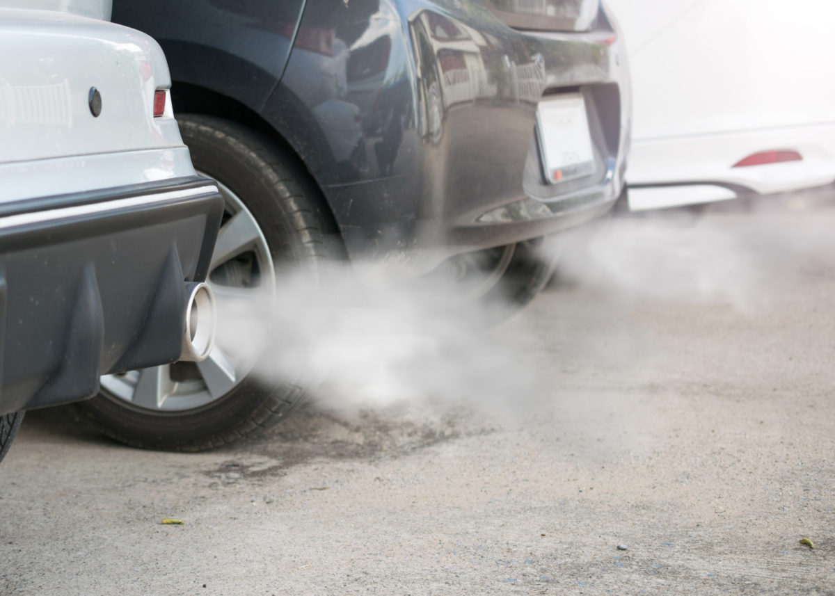 Combustion fumes coming out of car exhaust pipe